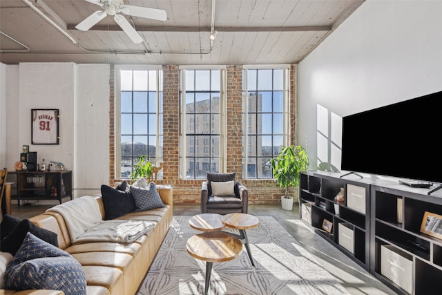 living room featuring rail lighting, brick wall, and ceiling fan