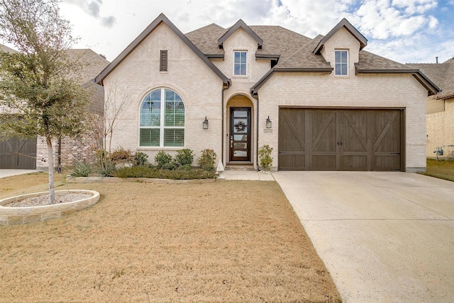 french country style house with a garage