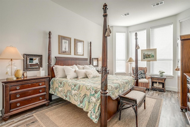 bedroom with hardwood / wood-style floors and multiple windows