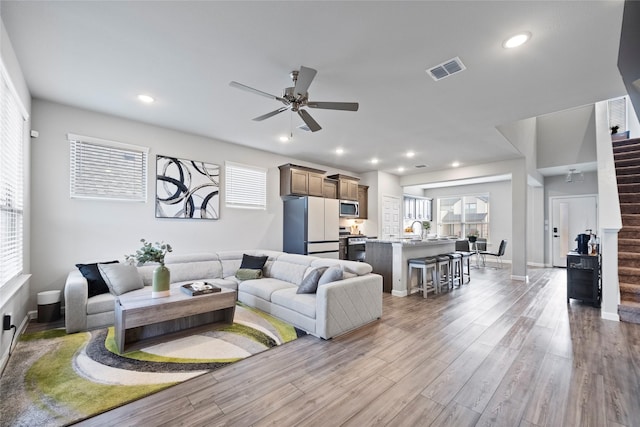 living room with sink, ceiling fan, and light hardwood / wood-style flooring