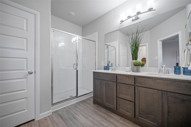 bathroom with hardwood / wood-style flooring, vanity, and an enclosed shower