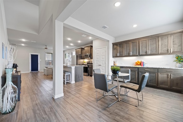 dining area featuring sink, light hardwood / wood-style floors, and ceiling fan