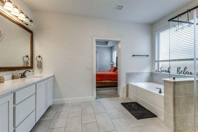 bathroom with tile patterned floors, vanity, and a washtub