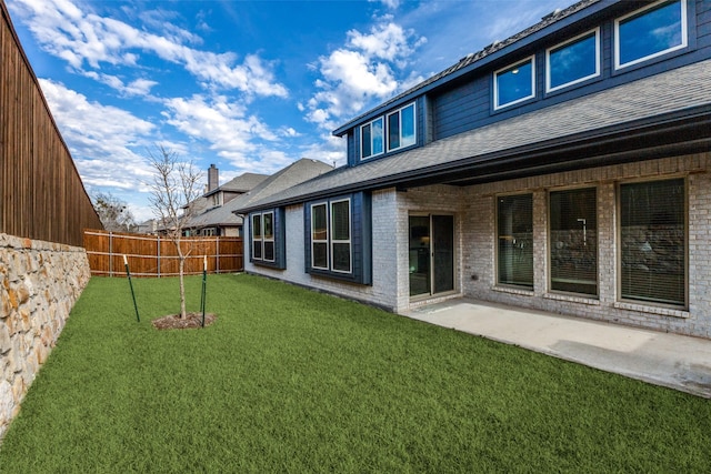 back of property with a yard and a patio area