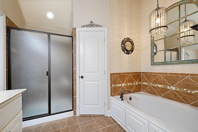 bathroom with an inviting chandelier, tile patterned floors, plus walk in shower, and vanity