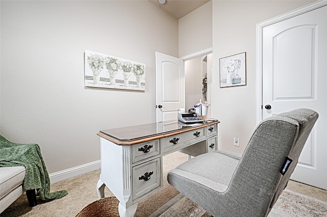 office area featuring light carpet and baseboards