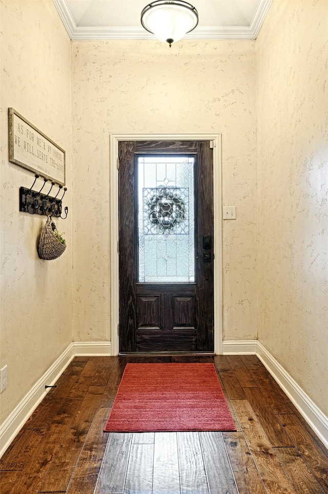 foyer entrance with ornamental molding and dark hardwood / wood-style floors