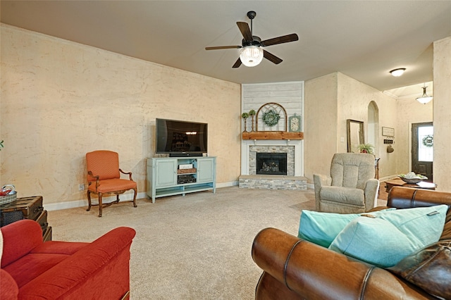 living area with baseboards, a fireplace, a ceiling fan, and carpet flooring