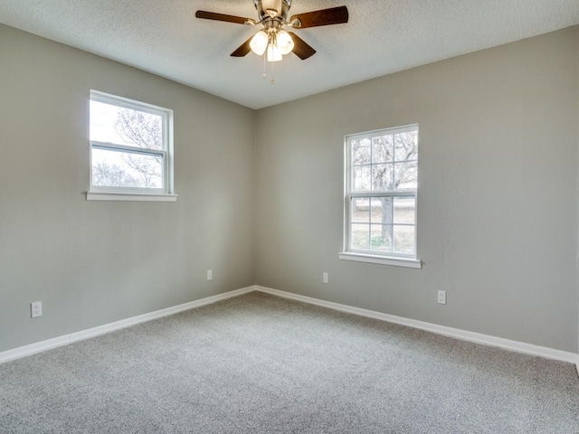 carpeted empty room with a healthy amount of sunlight, a textured ceiling, and ceiling fan