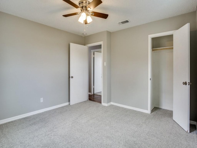 unfurnished bedroom with light colored carpet, a closet, and ceiling fan