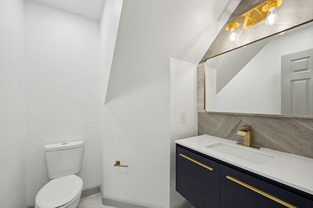 bathroom featuring vanity, toilet, and decorative backsplash