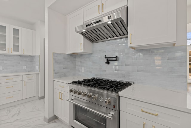 kitchen with backsplash, range hood, light stone counters, stainless steel range, and white cabinets