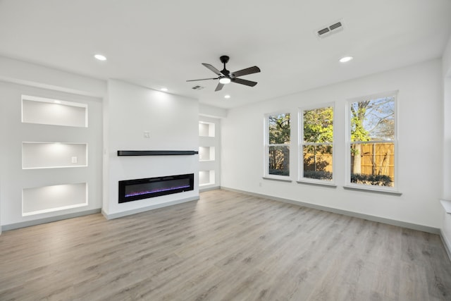 unfurnished living room featuring ceiling fan and light wood-type flooring