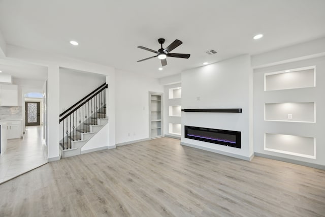 unfurnished living room featuring ceiling fan and light hardwood / wood-style floors