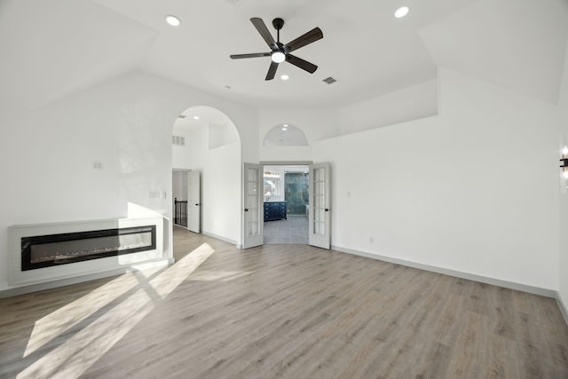 unfurnished living room featuring ceiling fan, high vaulted ceiling, and light hardwood / wood-style floors