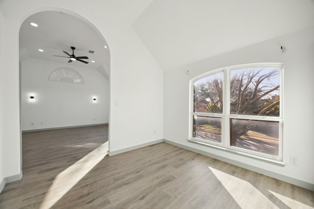 empty room featuring hardwood / wood-style flooring, ceiling fan, and vaulted ceiling