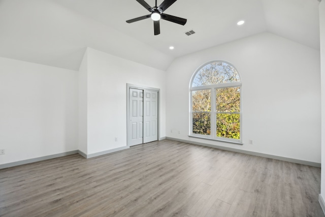 unfurnished bedroom with vaulted ceiling, light hardwood / wood-style floors, a closet, and ceiling fan