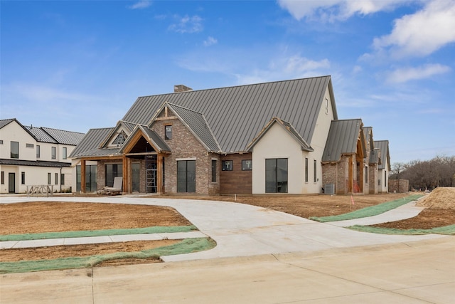 view of front of home with central AC unit and a front yard