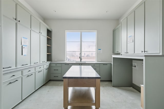 kitchen with gray cabinets, a center island, and sink