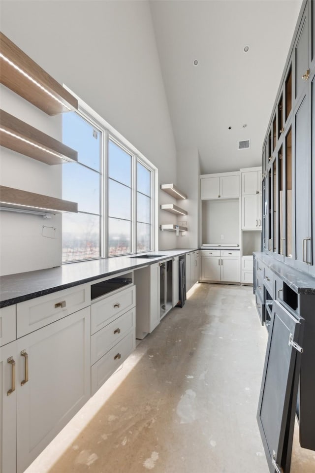 kitchen with high vaulted ceiling and white cabinets