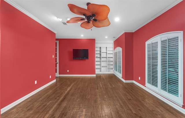 empty room featuring dark wood-type flooring, built in features, ornamental molding, and ceiling fan