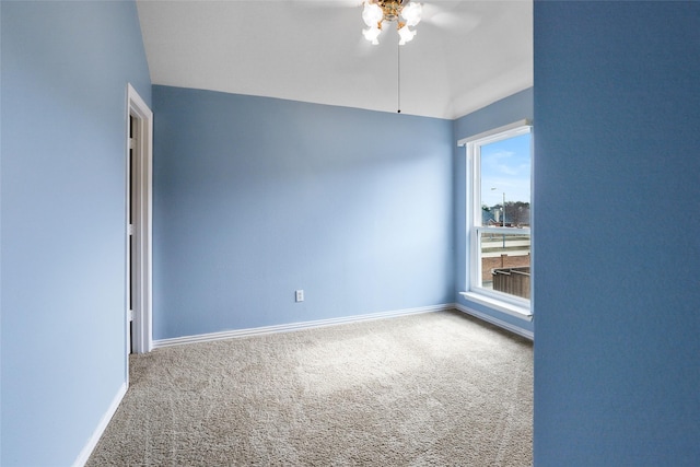 carpeted spare room featuring lofted ceiling and ceiling fan