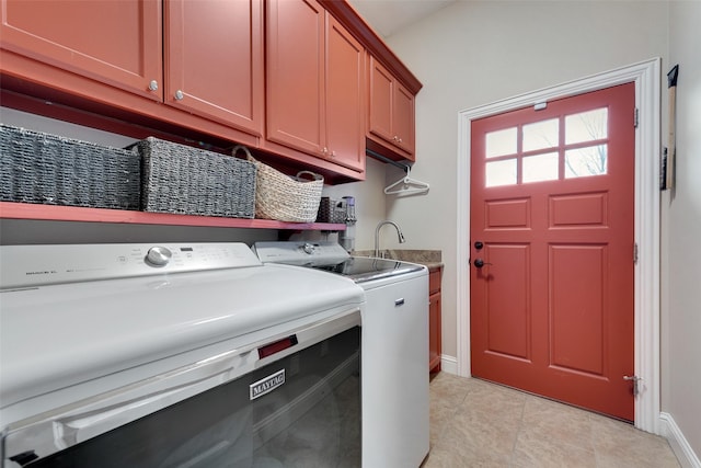 washroom featuring cabinets, light tile patterned floors, and washer and clothes dryer