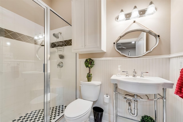 bathroom with toilet, a shower with shower door, and sink