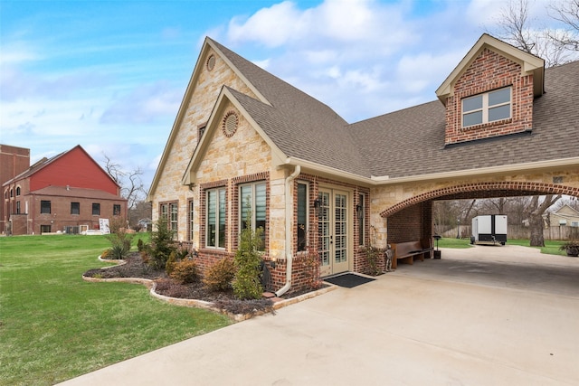 view of front of home with french doors, a carport, and a front lawn