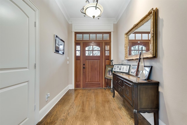 entrance foyer featuring crown molding and light wood-type flooring