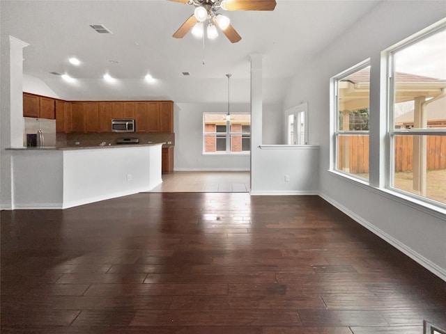 unfurnished living room with ceiling fan, lofted ceiling, and dark hardwood / wood-style flooring