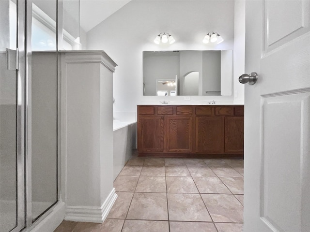 bathroom featuring tile patterned flooring, vaulted ceiling, separate shower and tub, and vanity