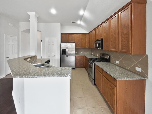 kitchen with light tile patterned flooring, lofted ceiling, sink, stainless steel appliances, and decorative backsplash