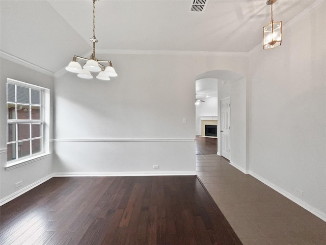 unfurnished dining area with ornamental molding, vaulted ceiling, ceiling fan, and dark hardwood / wood-style flooring