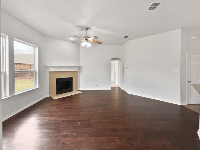 unfurnished living room featuring dark wood-type flooring and ceiling fan