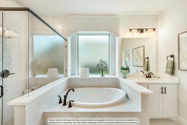 bathroom with vanity, plenty of natural light, and separate shower and tub