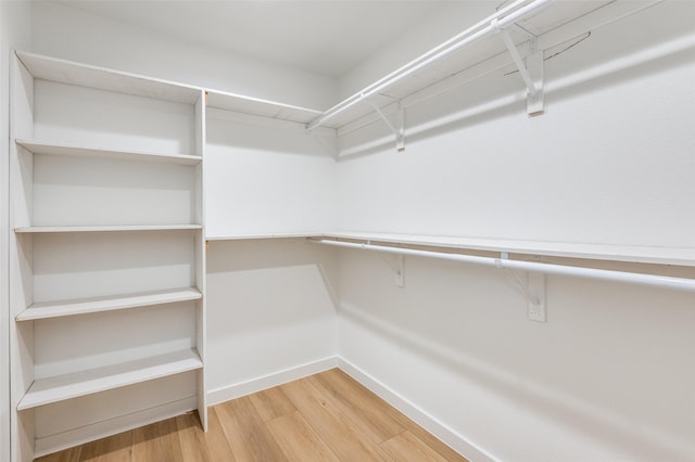 walk in closet with hardwood / wood-style floors