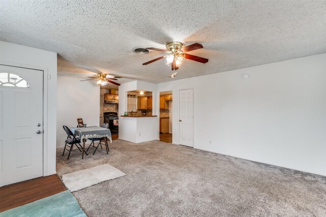 carpeted empty room featuring a textured ceiling and ceiling fan