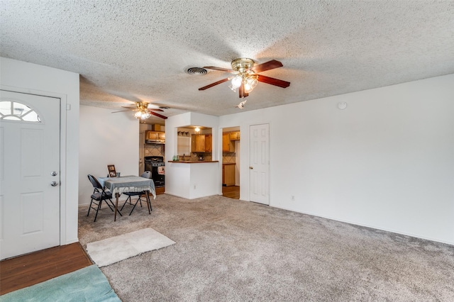 living room featuring ceiling fan, carpet, and a textured ceiling