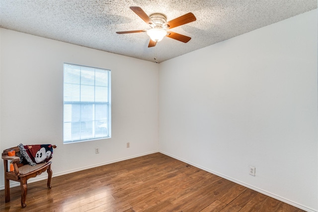 unfurnished room featuring dark wood-type flooring, ceiling fan, and a textured ceiling