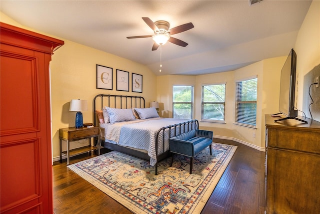 bedroom with dark hardwood / wood-style flooring, vaulted ceiling, and ceiling fan