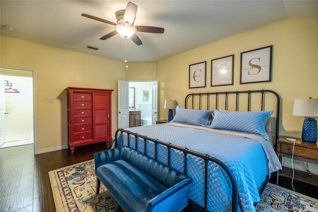 bedroom with ensuite bathroom, dark wood-type flooring, and ceiling fan