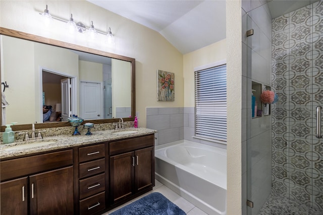 bathroom with vaulted ceiling, shower with separate bathtub, vanity, and tile patterned floors