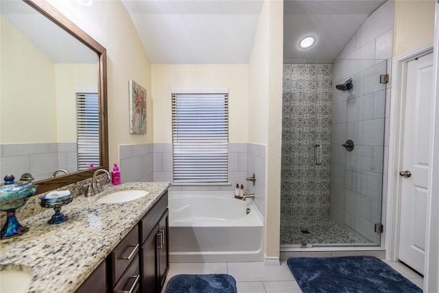 bathroom with tile patterned floors, lofted ceiling, shower with separate bathtub, and vanity