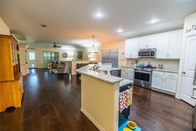 kitchen with sink, white cabinetry, a center island, appliances with stainless steel finishes, and pendant lighting