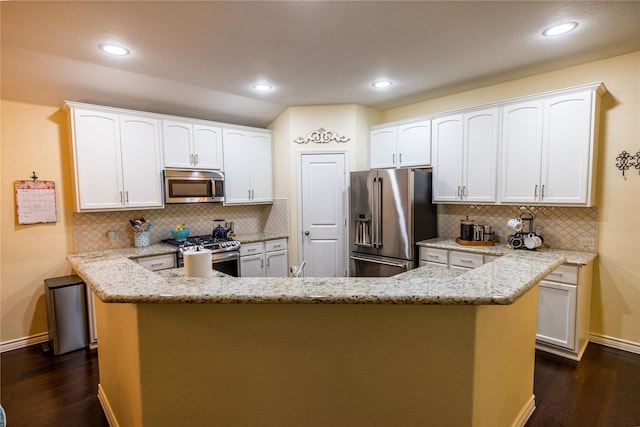 kitchen featuring white cabinetry, dark hardwood / wood-style flooring, kitchen peninsula, stainless steel appliances, and light stone countertops