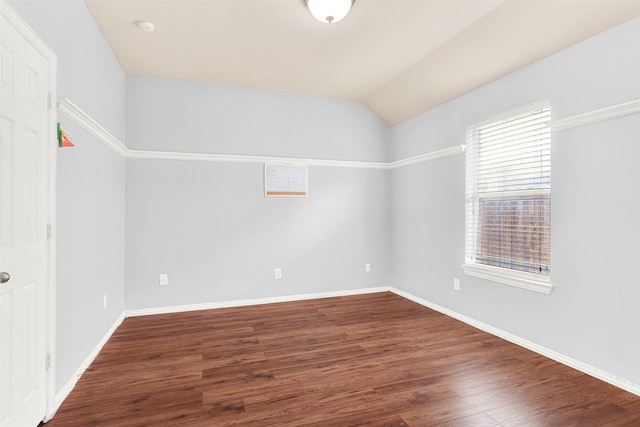 spare room featuring dark hardwood / wood-style flooring and vaulted ceiling