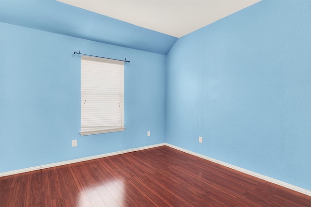 unfurnished room featuring lofted ceiling and hardwood / wood-style floors