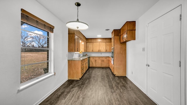 kitchen featuring dark hardwood / wood-style flooring, sink, plenty of natural light, and hanging light fixtures