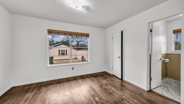 unfurnished bedroom with dark hardwood / wood-style flooring and a closet